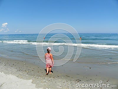 Young girl contemplating the mesmerizing ocean waves Editorial Stock Photo