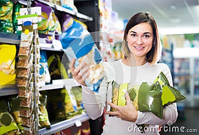 Young girl customer looking for tasty snacks in supermarket Stock Photo
