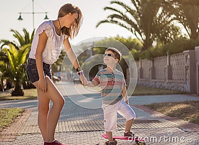 Young girl and cute kid with a skateboards outdoor Stock Photo