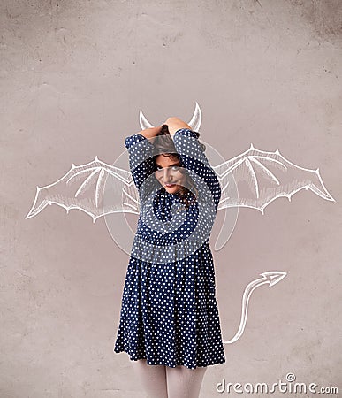 Young girl with devil horns and wings drawing Stock Photo