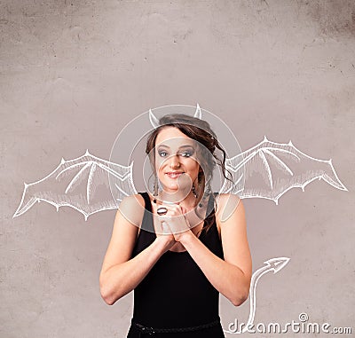 Young girl with devil horns and wings drawing Stock Photo