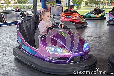 Young girl on dodgem bumper car ride at amusement fair Editorial Stock Photo