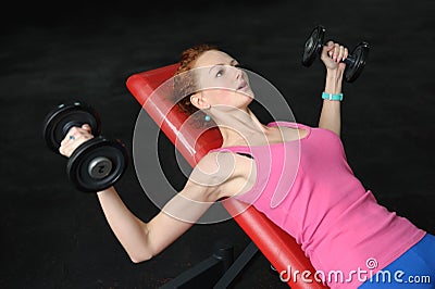 Young girl doing Dumbbell Incline Bench Press workout Stock Photo