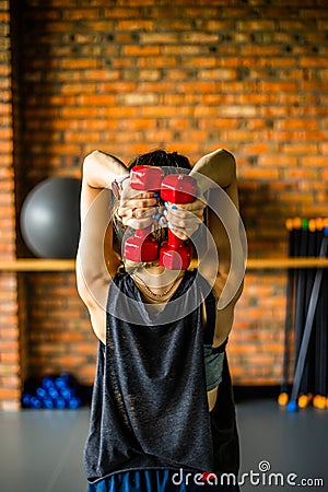 Young girl is doing fitness and different exercises in the gym. Sport is health. Many sports equipment on e background. Themes of Stock Photo