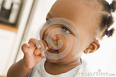 Young girl eating carrot indoors Stock Photo