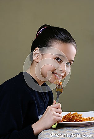 A young girl enjoying her ribbon pasta Stock Photo