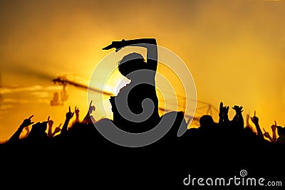 Young girl enjoys a rock concert, Silhouette on sunset Stock Photo