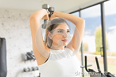 young girl exercising her forearms with dumbbells in a gym Stock Photo