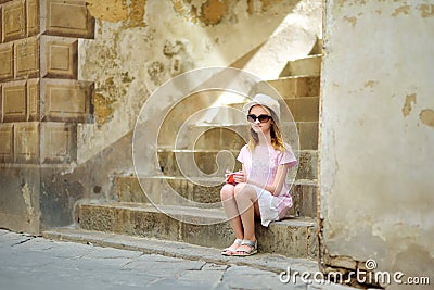 Young girl exploring in Montalcino town, located on top of a hill top and surrounded by vineyards, known worldwide for the Stock Photo