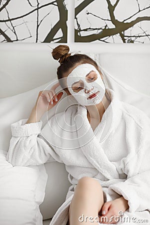 Young girl with face mask. skin care. Young beautiful girl relaxing with facial masks on over white background Stock Photo