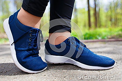 Young girl feet in sport shoes sneakers on park alley in spring Stock Photo