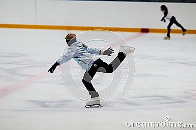 Young girl figure skater on the ice arena in motion. Editorial Stock Photo