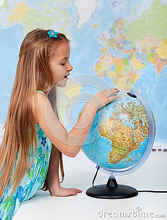 Young girl finding places on a globe Stock Photo