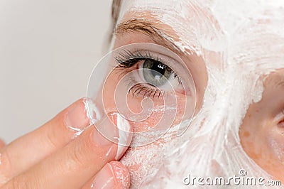 Young girl fingers applying face mask moisturizer Stock Photo