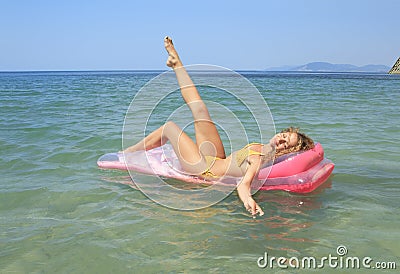 Young girl floating on a mattress in the sea Stock Photo