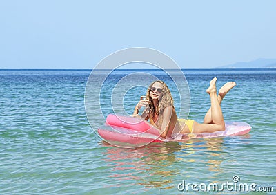 Young girl floating on a mattress in the sea Stock Photo