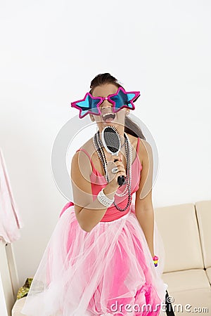 Young girl with funny glasses singing Stock Photo