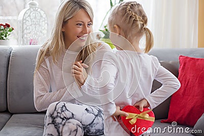 Young girl is giving present to her mother Stock Photo