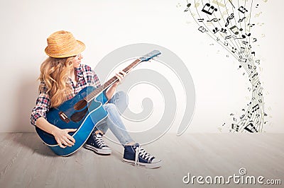 Young girl guitar play sitting on a floor Stock Photo