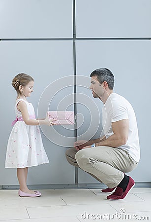 Young girl handing present to her father Stock Photo