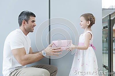 Young girl handing present to her father Stock Photo