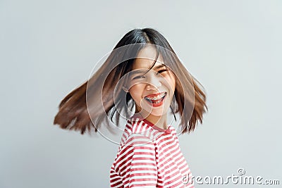 Young girl happy smile and cheerful in red dress in a swirling gesture and hair fluttering along the rotating force. Stock Photo
