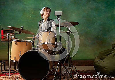 Young girl in headphones recording music video blog home lesson, playing drums or making broadcast internet tutorial Stock Photo