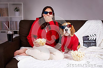 A young girl with her dog beagle in 3 d glasses watching a movie at home Stock Photo