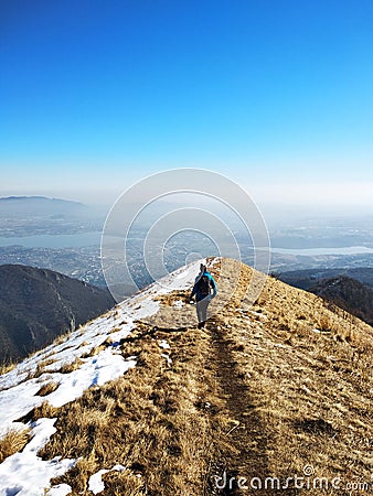 Young girl hiking on top of a mountain overlooking a distant valley, sense of freedom, independence and confidence Stock Photo