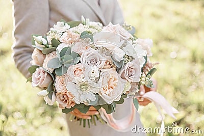 Young girl holding a beautiful spring bouquet. flower arrangement with garden roses. Color light pink. Bright dawn or Stock Photo