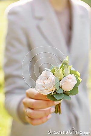 Boutonniere. Young girl holding a beautiful spring Flowers. flower arrangement with roses. Color light pink. Bright dawn Stock Photo
