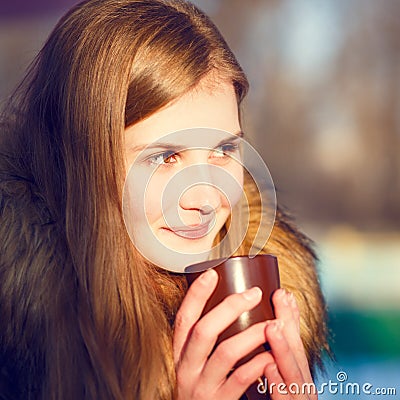 Young girl holding cup of coffee in winter park Stock Photo