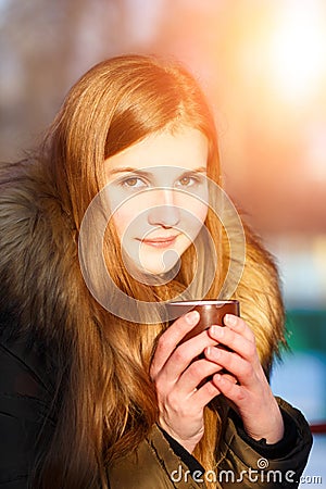 Young girl holding cup of coffee in winter park Stock Photo