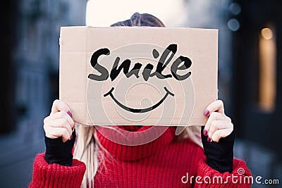 A young girl is holding a sign with a smile. Happy and smiling concept Stock Photo