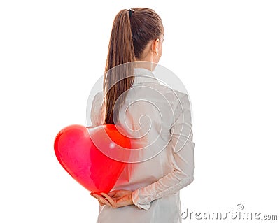 A young girl holds in his hand behind the big red heart shaped balloon Stock Photo