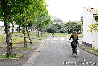 Young girl on the Ile de RÃ© by bike in the alley in France Editorial Stock Photo