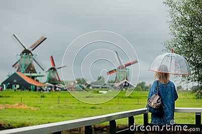 Girl stay on bridge with dutch mills Stock Photo