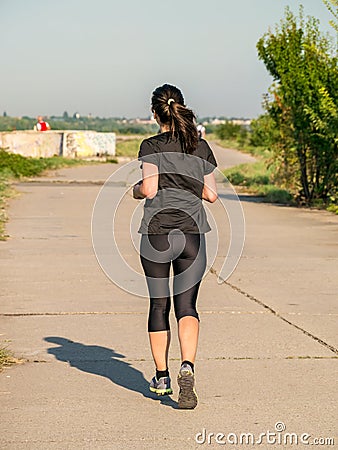 Young girl jogging in the morning. Woman working out on Lacul Morii or Windmill lake in Bucharest Editorial Stock Photo