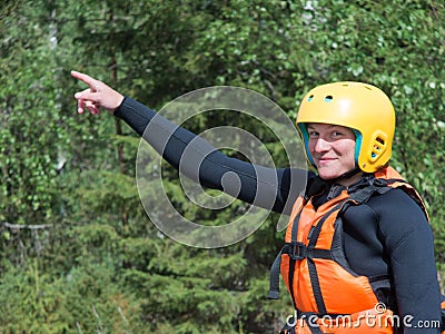 Young girl in a life jacket and helmet standing with his hand raised Stock Photo