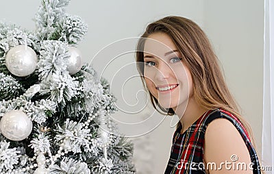 Young girl with long blondy hair wearing dress near a Christmas tree Stock Photo