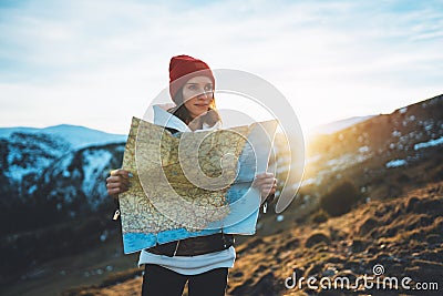 Young girl look and hold in hands map, people planning trip, hipster tourist on background sun flare nature, enjoy journey land Stock Photo