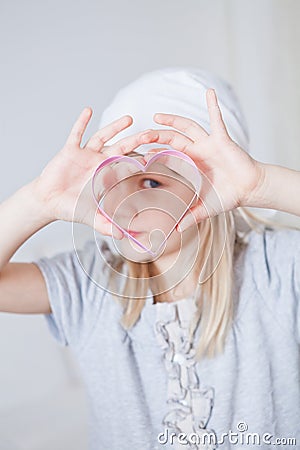 Young girl looking through gingerbread biscuit cutter Stock Photo