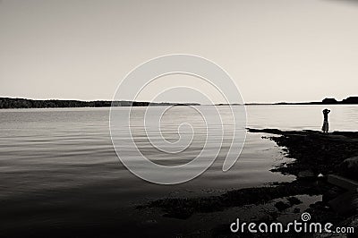 Young girl looking over calm water Stock Photo