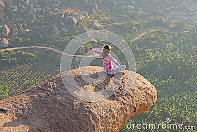 A young girl in a lotus pose is greeting the sun on a background Stock Photo