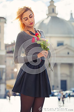 Young girl in love. Blonde teenager with roses in hand. Stock Photo