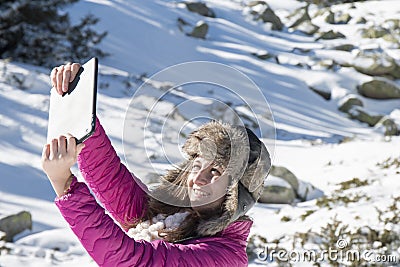 Young girl makes selfie photos with a tablet in winter Stock Photo