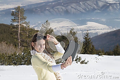 Young girl makes selfie photos with a tablet in winter Stock Photo