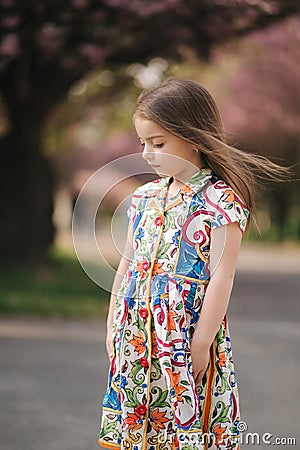 Young girl model poses to photographer. Female kid i beautiful dress outside. End of quarantine Stock Photo
