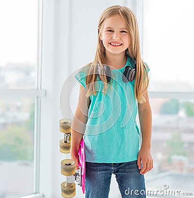 Young girl in modern summer clothes with skate Stock Photo