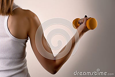 Young girl muscles athletes hand holding dumbbell on dark background Stock Photo